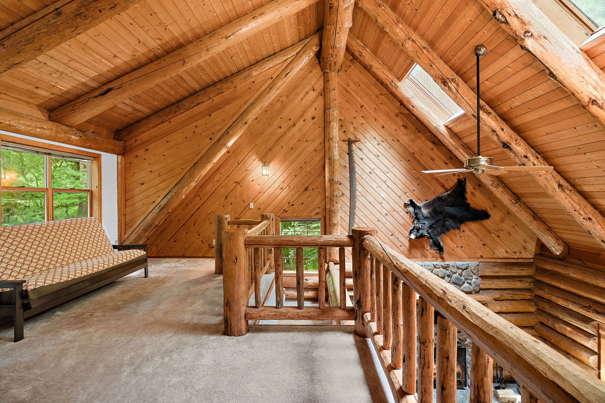 Loft with a futon, skylight, and views down to the fireplace.