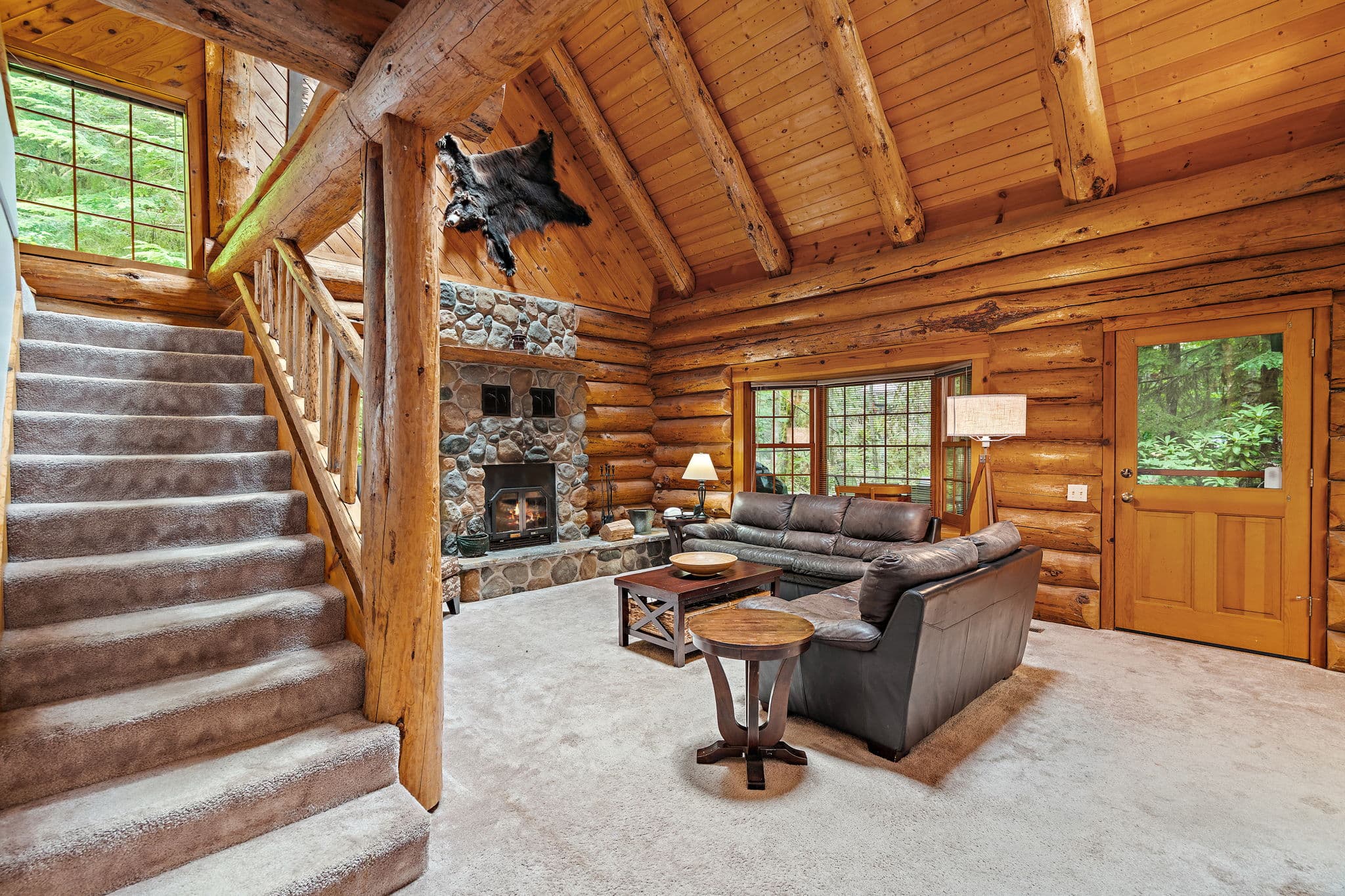 River rock fireplace and vaulted log trusses in the living room.