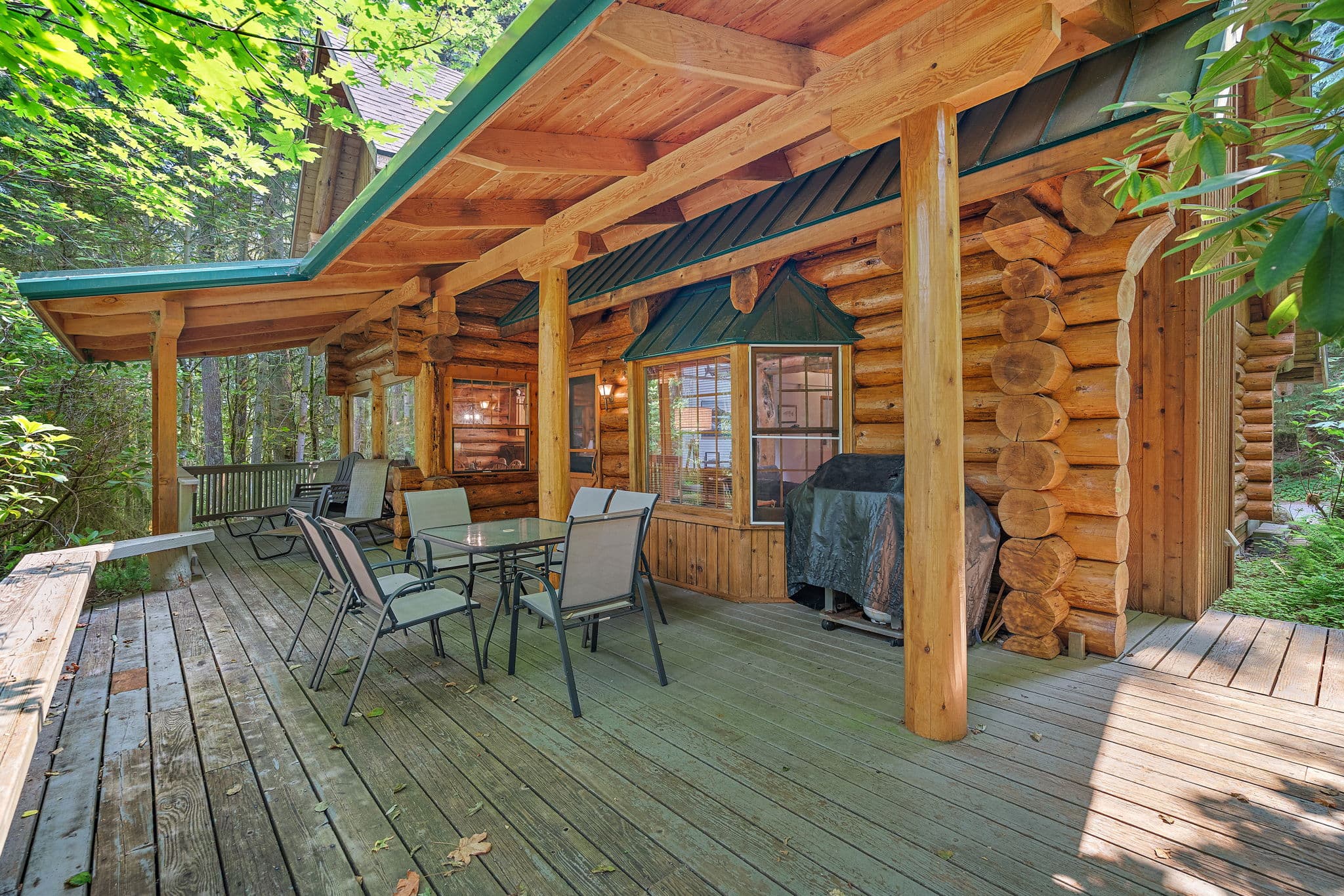 Wraparound covered deck with forest on every side.